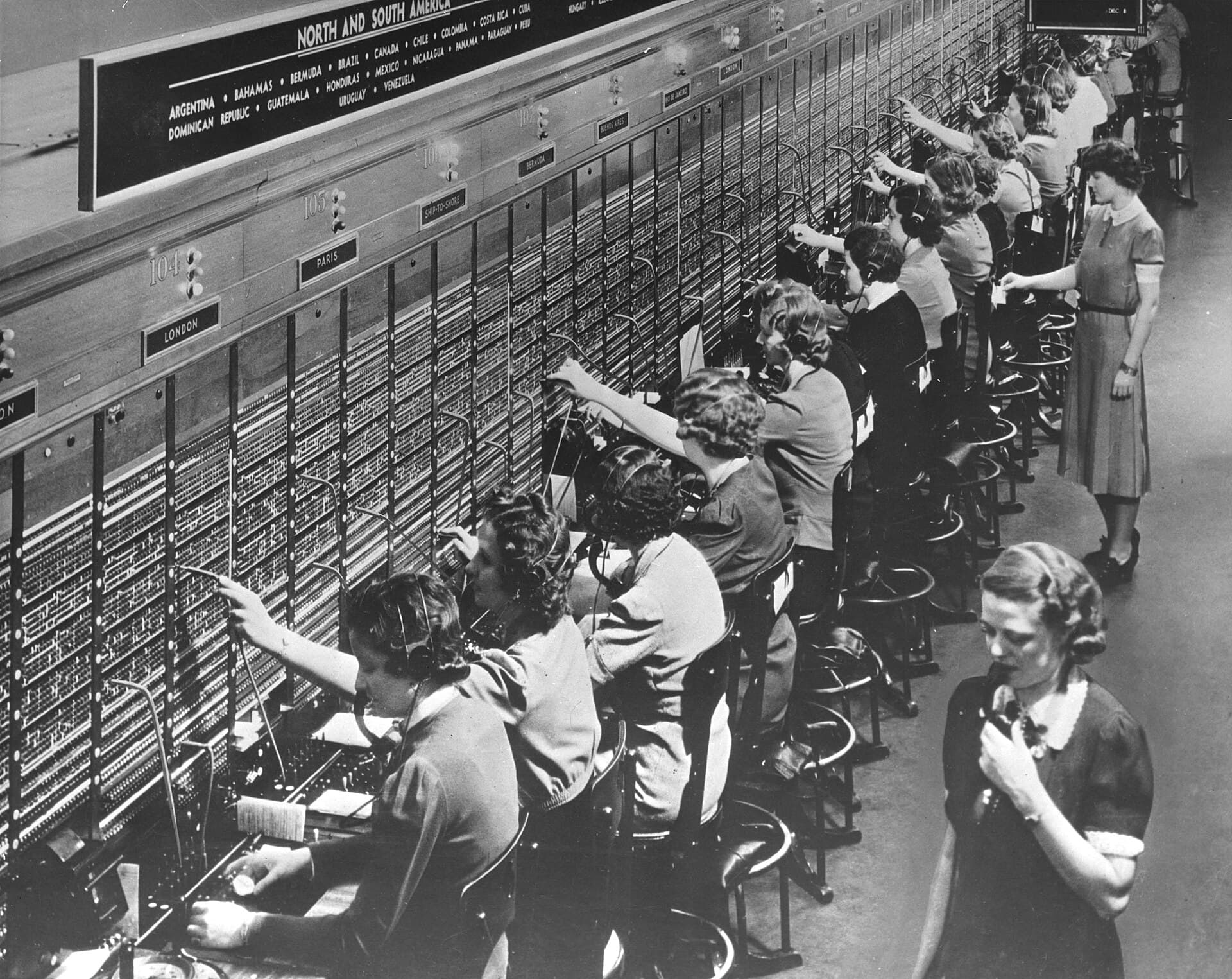 Operators at a Bell System international switchboard connecting calls to London, Paris, and the Americas